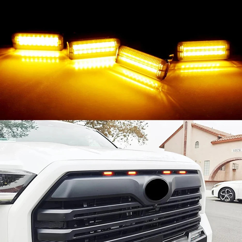 Smoked Amber Grille Lights glowing amber at night and installed on the grille of a white pickup truck