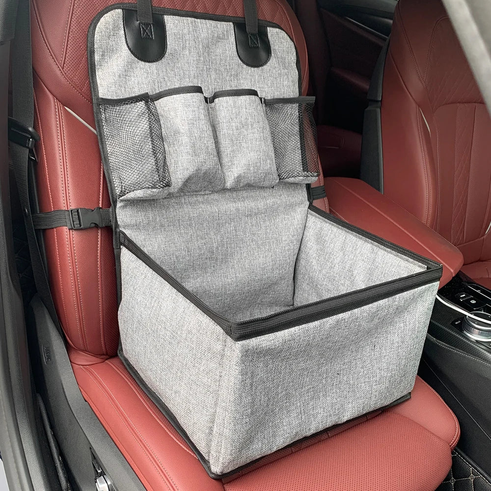 Close-up view of the mesh storage pockets and safety straps on the foldable pet travel carrier seat.