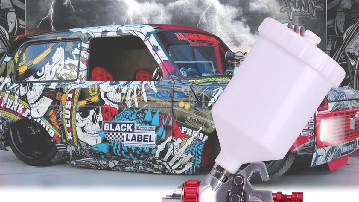 An HVLP spray gun labeled H827, shown prominently in the foreground against a white lower section and a car covered in graffiti-style artwork above. The product is a silver spray gun with a white plastic cup, red adjustment knobs, and a gray trigger handle.