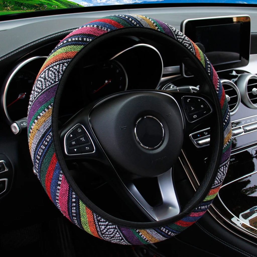 Multicolour striped bohemian linen steering wheel cover with black and white diamond pattern fitted on a car steering wheel