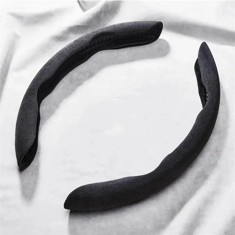 Suede Car Steering Wheel Cover in black, two-piece non-slip grip protector on a light fabric background