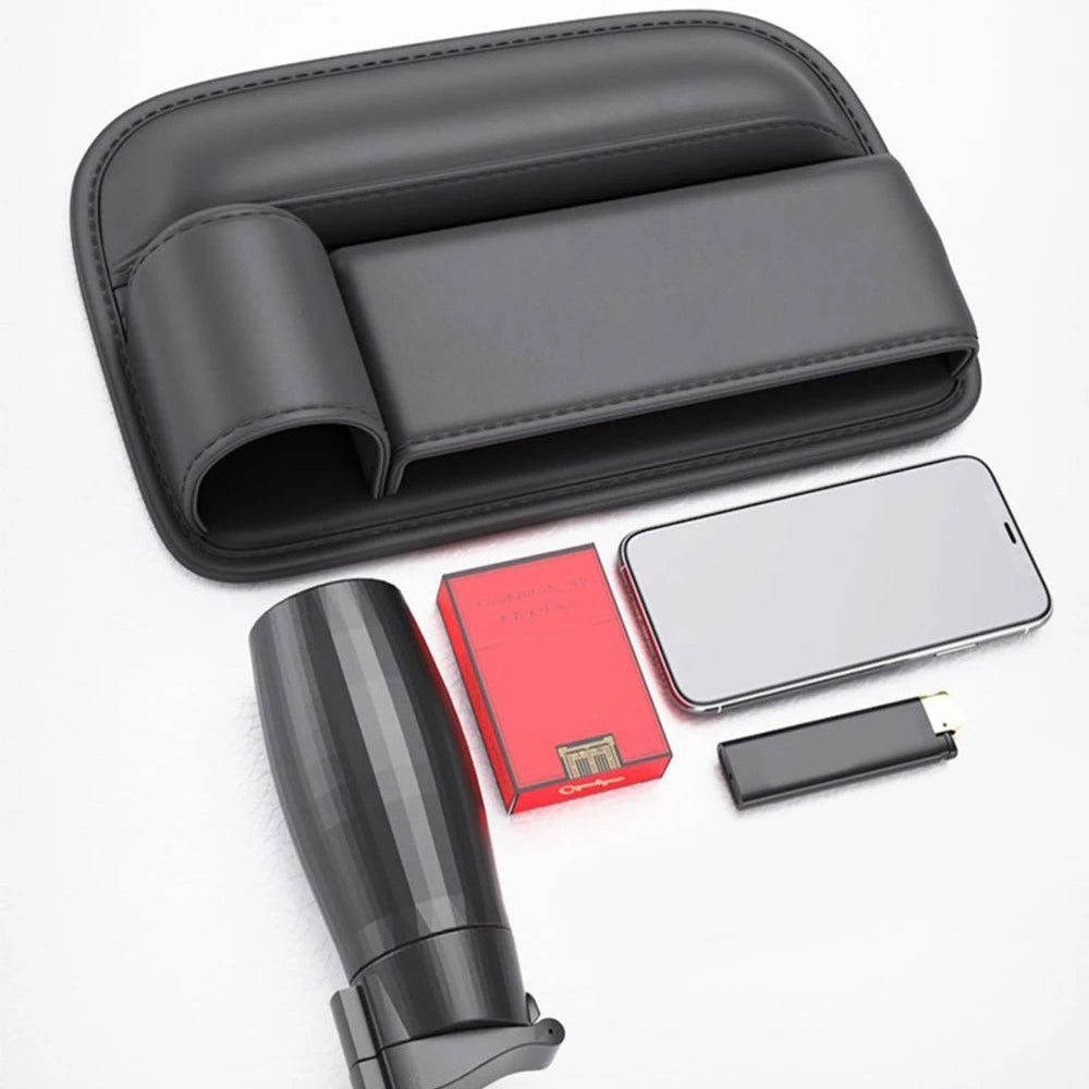 Leather seat gap organiser shown with included accessories laid out flat, including a phone, cards and a small storage tin.