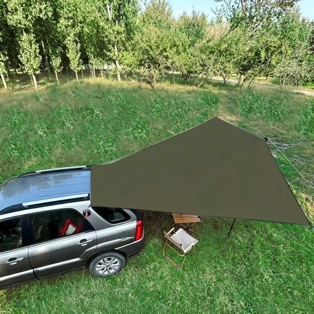 Expedition Side Sunshade shading a camp table and chair beside a silver SUV parked in a grassy park