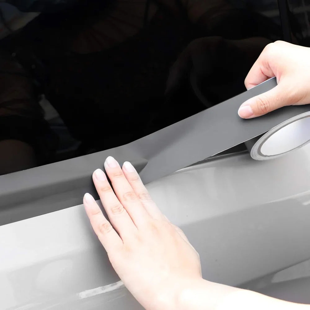 Hand applying Matte Black Trim Wrap vinyl film to a car's window trim strip
