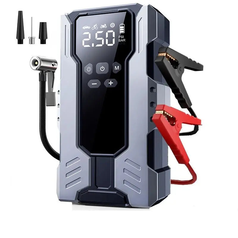 A portable car jump starter with a digital display screen, featuring a gray and black rugged body, red and black jumper clamps, and three nozzle attachments on a white background.