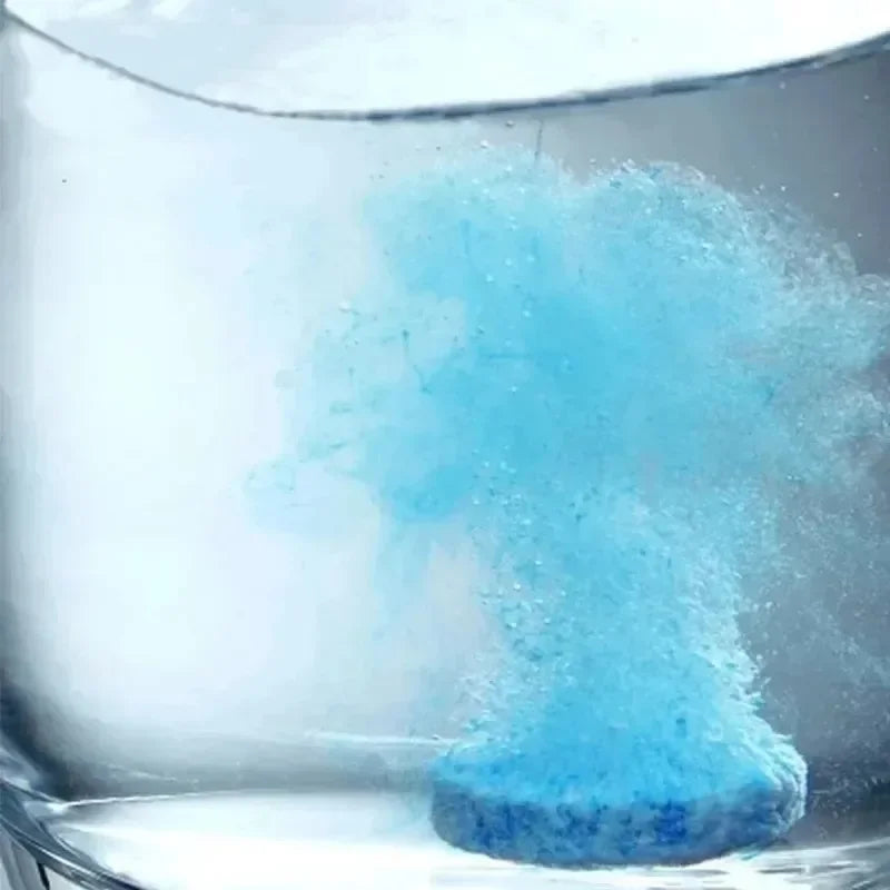 Close-up of a Windscreen Washer Fluid Tablet effervescing and dissolving in a glass of water