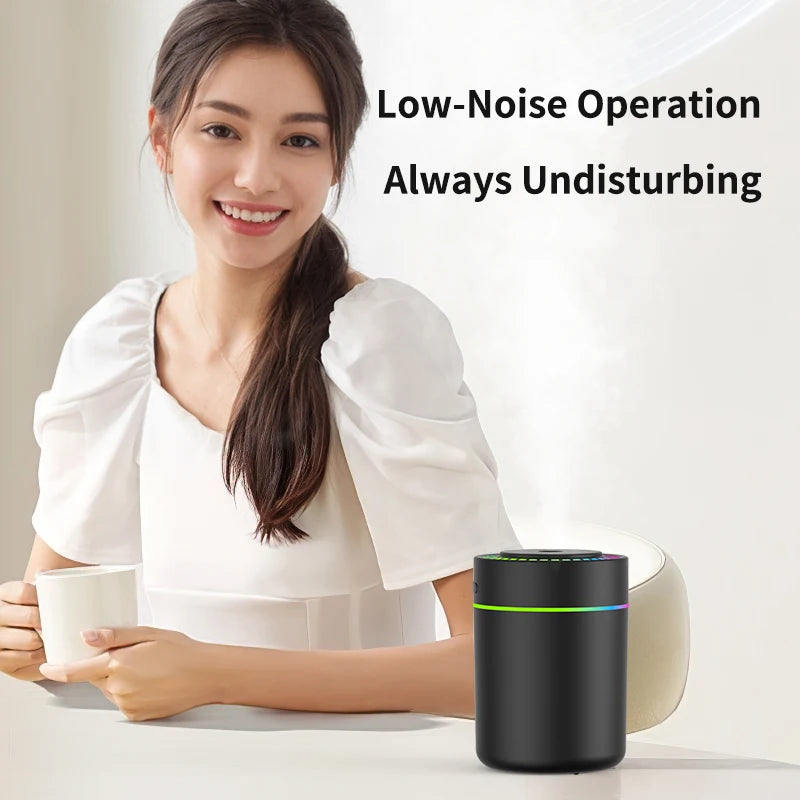Woman at a table with a black car aroma diffuser diffusing mist in the foreground, low-noise operation
