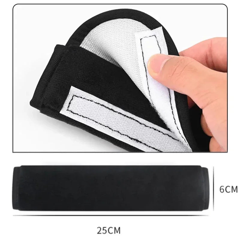 Hand peeling back the Velcro fastening on a black seat belt cover showing 25cm length and 6cm width