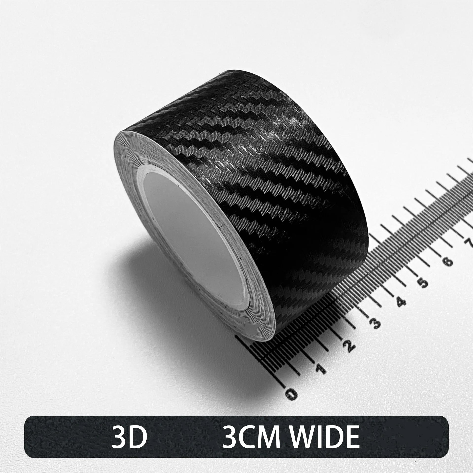 Roll of black Textured 3D carbon fibre wrap tape, 3cm wide, shown on a white background with a ruler for scale.