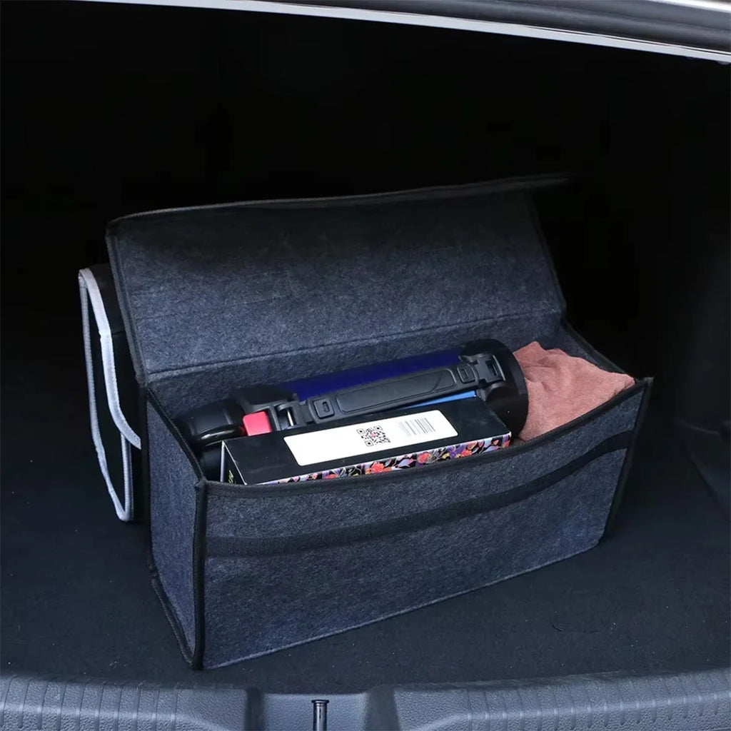 Dark grey felt storage box open in a car boot, holding tissue packs, a water bottle and other loose items to keep the boot organised.