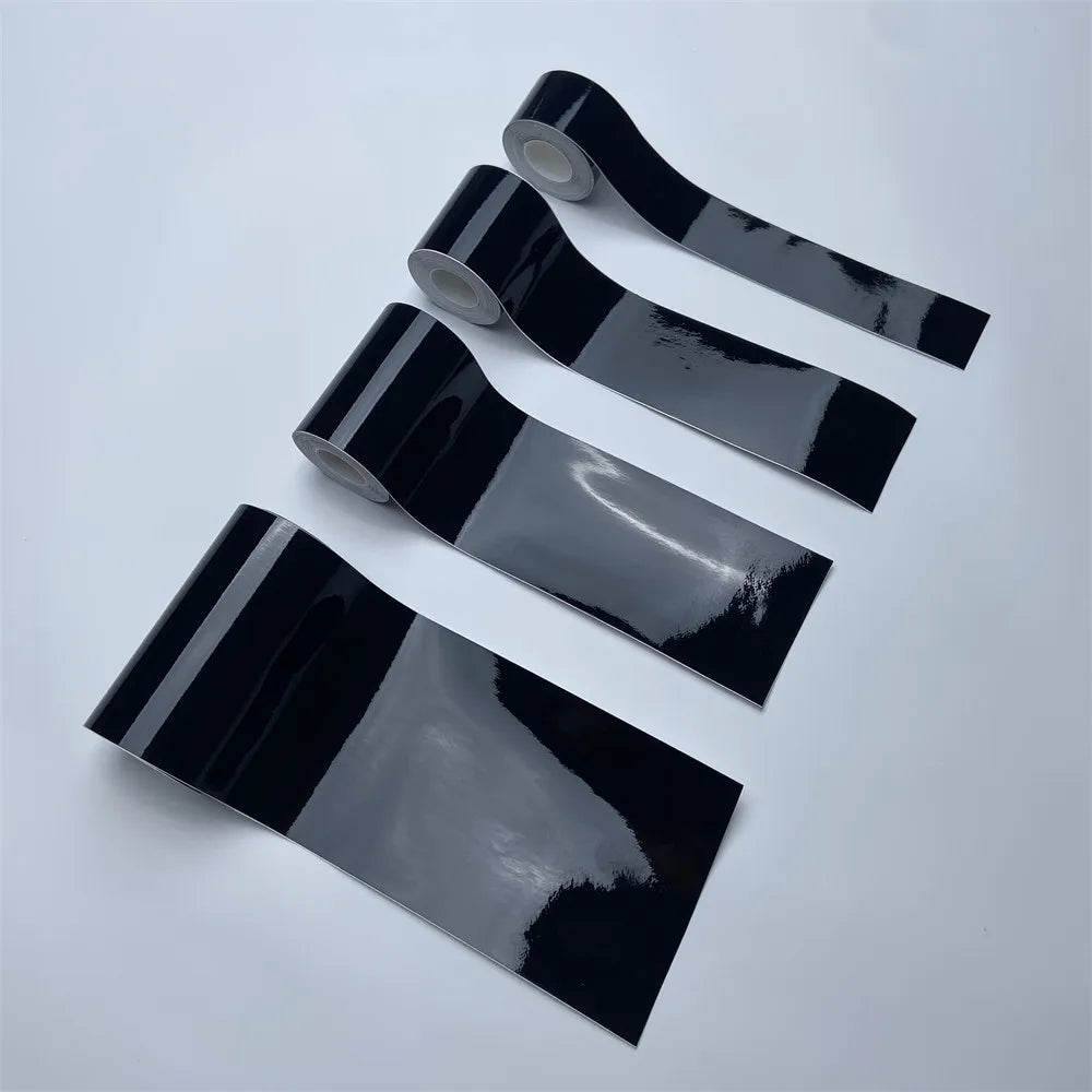 Four rolls of Gloss Black Trim Wrap vinyl film in different widths on a white background