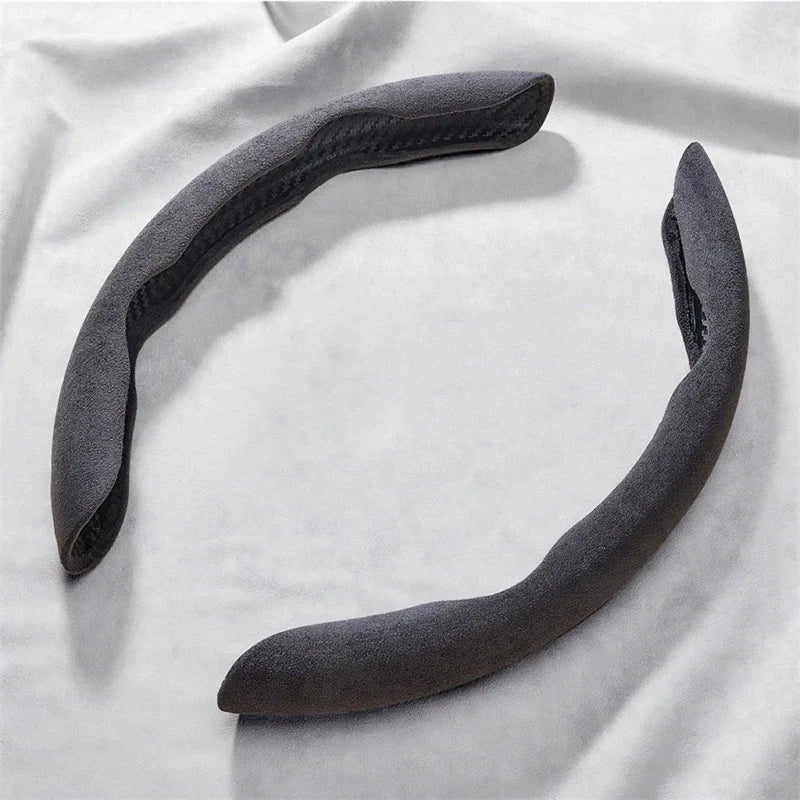Suede Car Steering Wheel Cover in grey, two-piece non-slip grip protector on a light fabric background