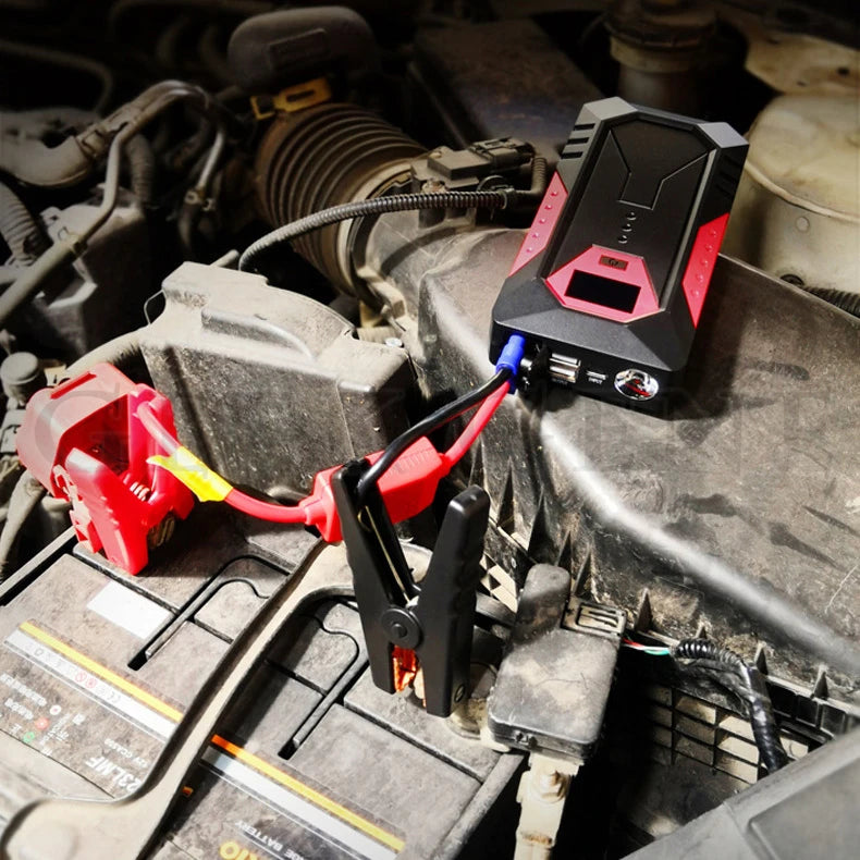 Compact Pocket Jump Starter connected to a car battery with red and black clamps in an engine bay