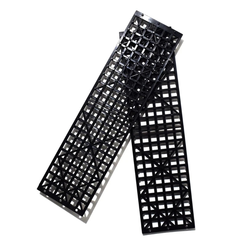 Two emergency tyre traction mats fanned out on white background showing textured grip surface