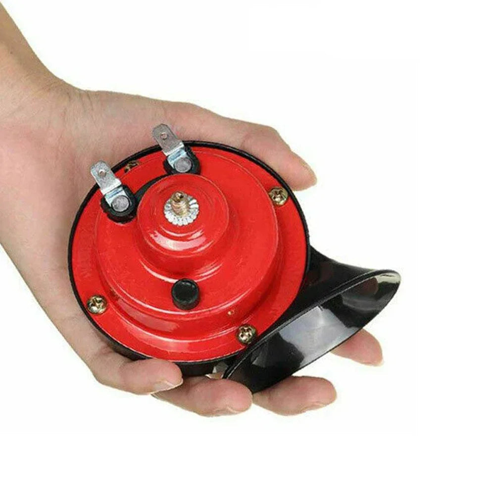 Hand holding a red snail air horn to show its compact size