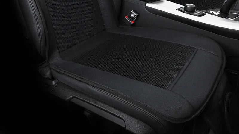 Black ventilated car seat cushion installed on vehicle seat showing stitching and mesh cooling panel detail