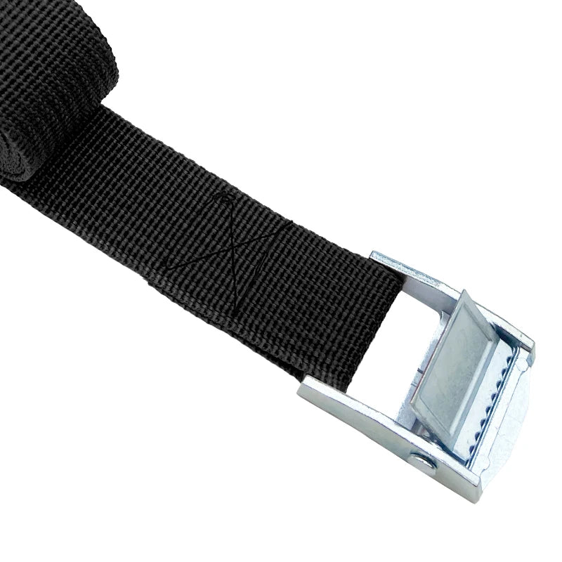 Close-up of black polyester webbing feeding through the metal cam buckle of a cargo strap
