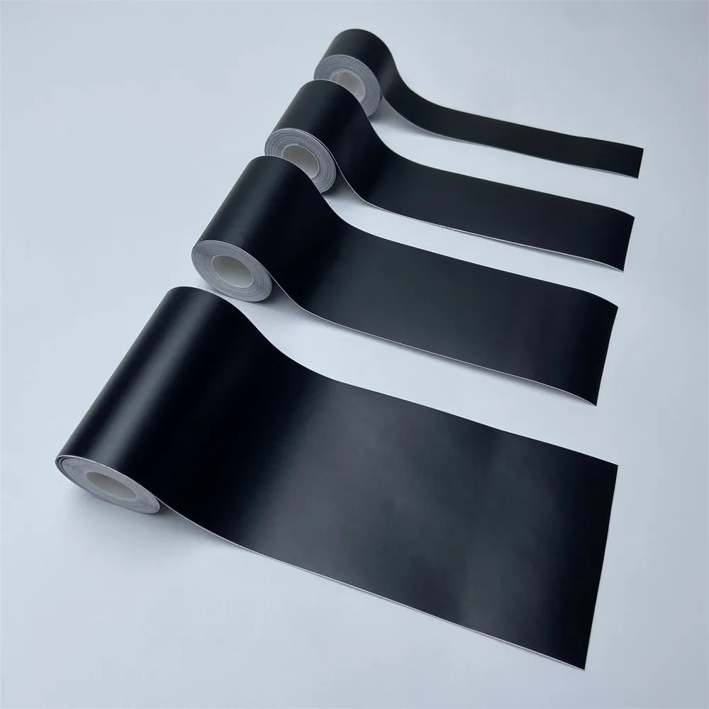 Four rolls of Matte Black Trim Wrap vinyl film in different widths on a white background