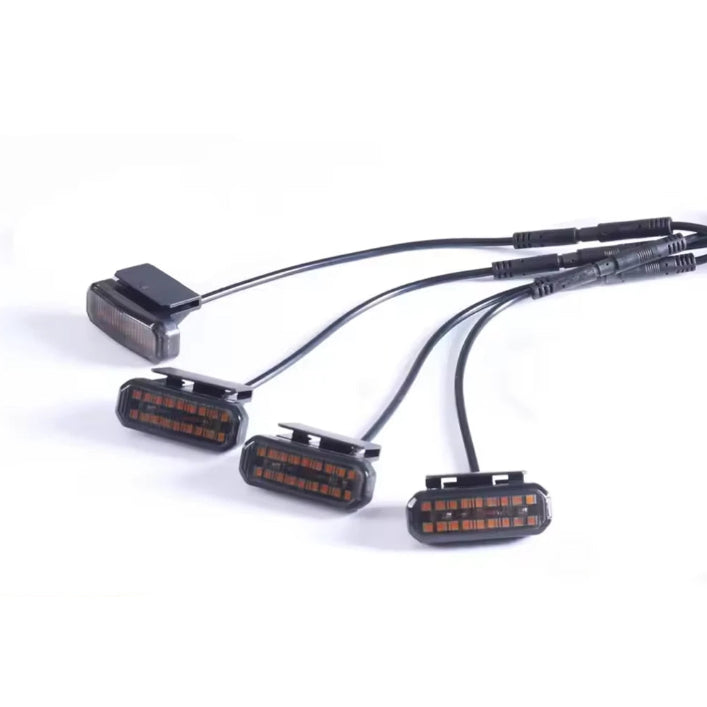 Four Smoked Amber Grille Lights with smoked lenses and wiring harness on a white background