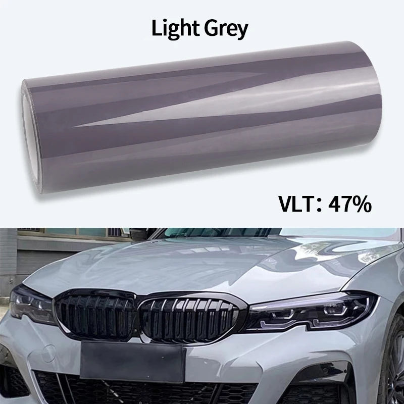 Roll of headlight PPF wrap film in Light Smoke Light Grey, rated VLT 47 percent, shown on a white background with the film applied to a BMW's headlight.