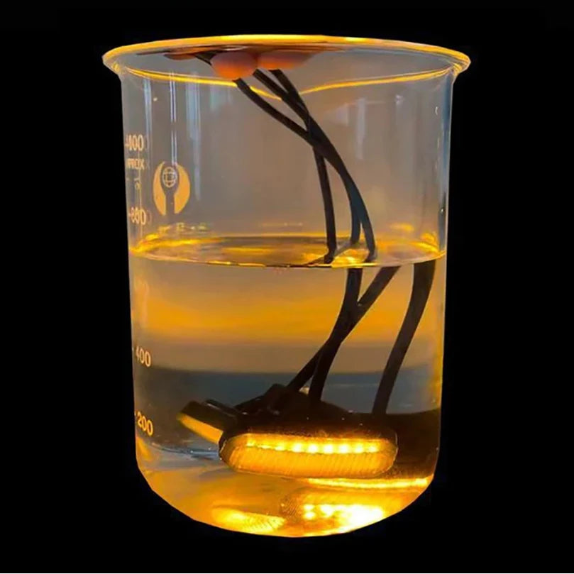 Smoked Amber Grille Light glowing amber while submerged in a beaker of water to show waterproof sealing