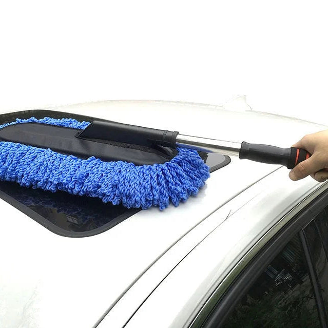 Blue microfibre wash brush mop dusting the sunroof glass of a white car