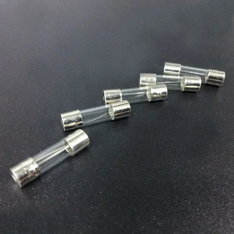 Five glass fuses from the Auto Glass Fuse Kit arranged in a row on a dark background