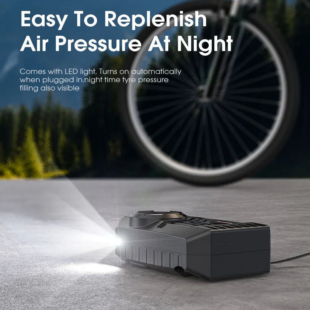 Mini Tyre Inflator with built-in LED work light illuminating the ground for night-time tyre pressure checks near a bicycle wheel.
