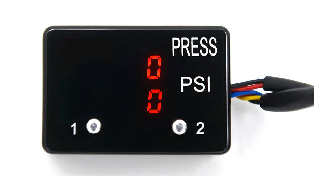 A black rectangular digital pressure gauge with a red LED display showing '0 PSI' and 'PRESS' text, with two screw terminals and multicolored wires on the right, photographed on a white background.