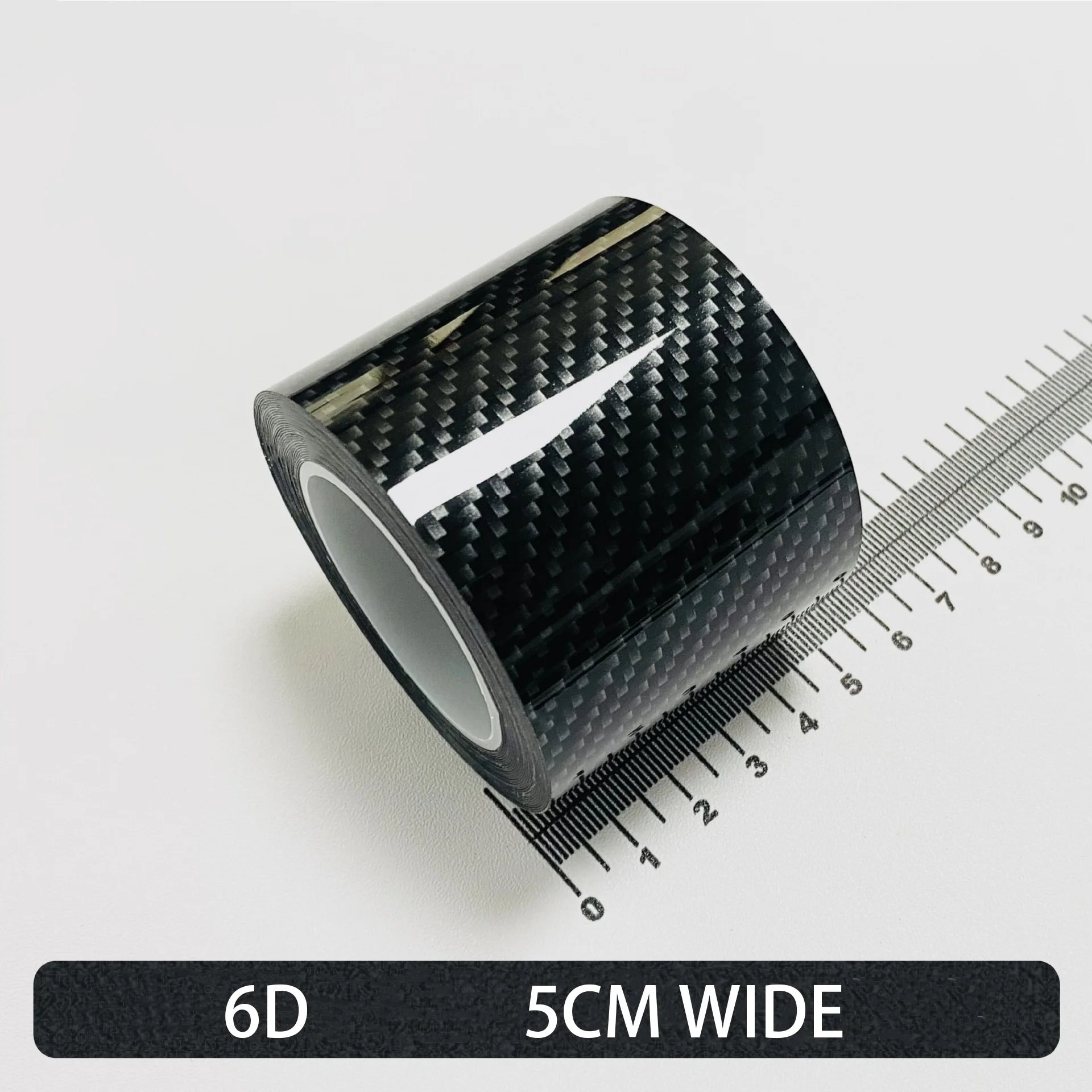 Roll of High-Gloss 6D carbon fibre wrap tape, 5cm wide, shown on a white background with a ruler for scale.