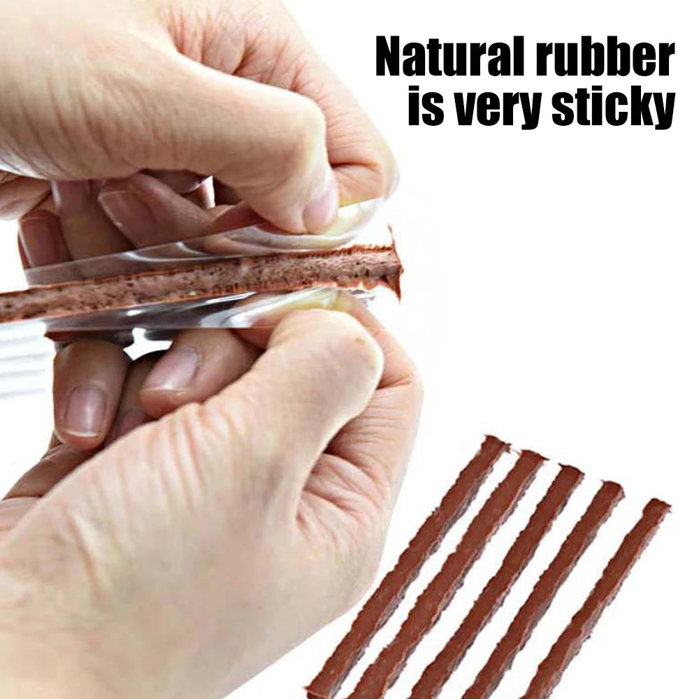 Hand pulling sticky natural rubber repair strip through the eyelet of a tyre plug insertion tool