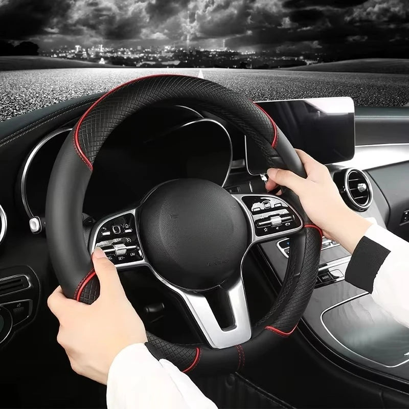 Hands gripping the Diamond Leather Steering Wheel Cover with red stitching while driving at night