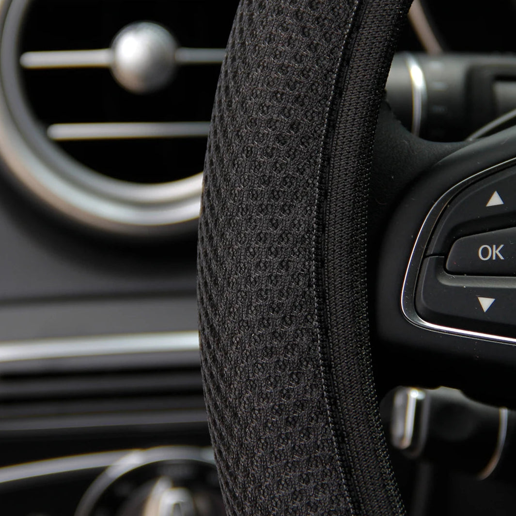 Close-up of black mesh steering wheel cover fabric texture showing breathable all-season grip