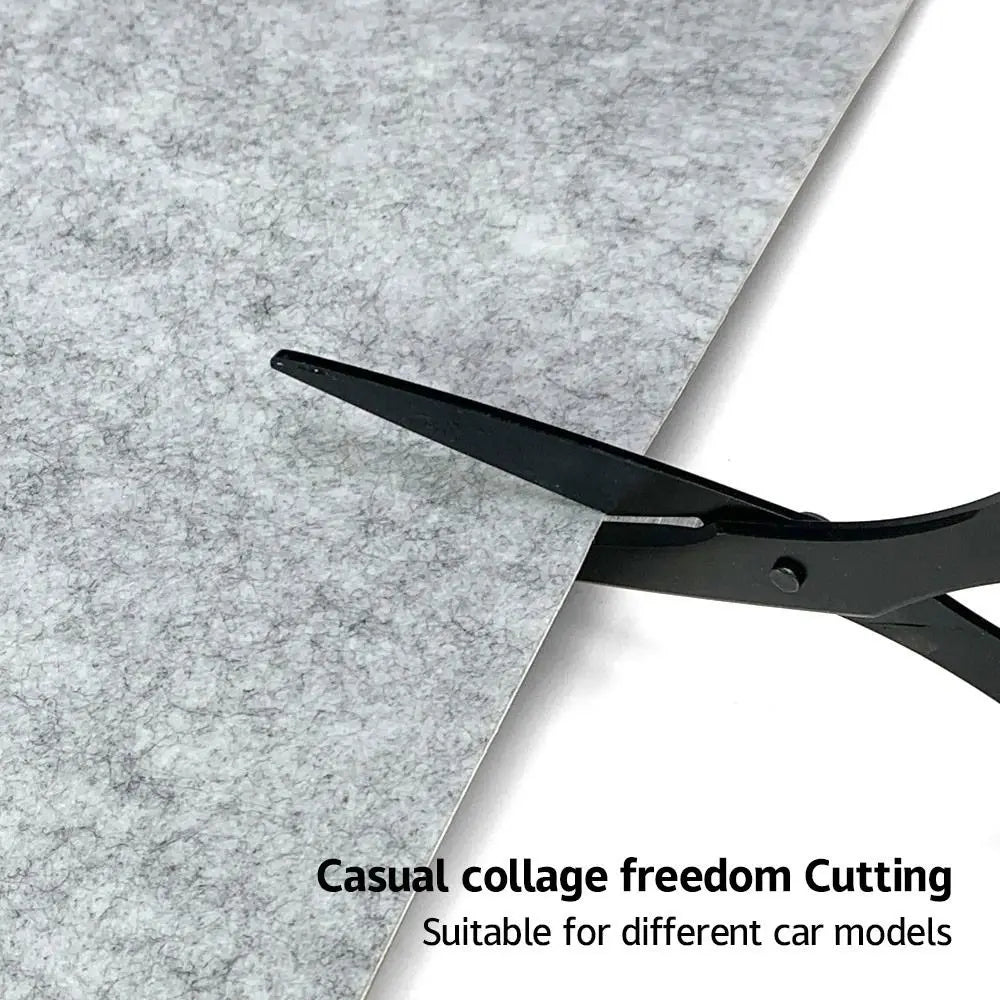 Scissors cutting grey self-adhesive felt lining to a custom shape for a car interior
