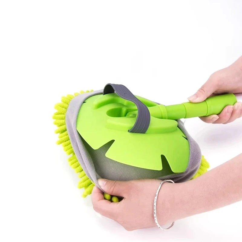 Green and gray cleaning brush held by a person on a white background