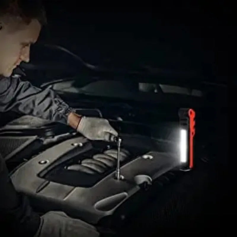Mechanic using Rechargeable COB Work Light to illuminate a car engine bay at night for roadside repairs