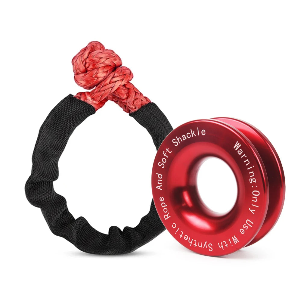 Red soft shackle rope loop beside a red anodised aluminium recovery ring with safety warning text
