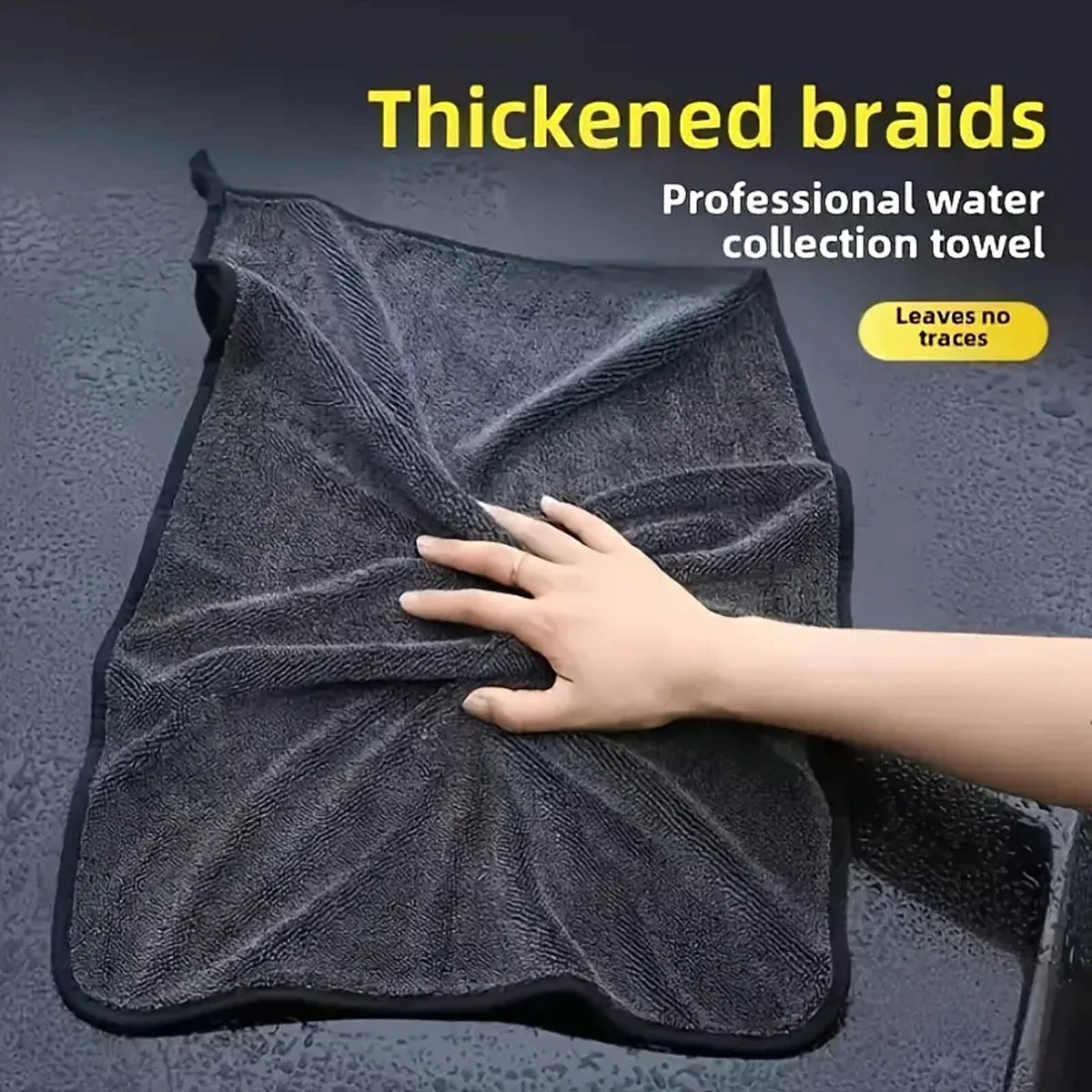 Hand pressing into a wet, twisted microfibre car drying towel on a car surface, professional water-collection towel