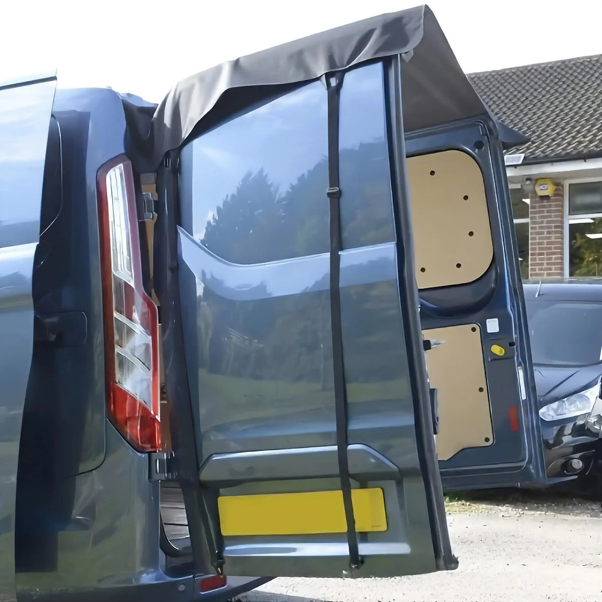 Close-up of the Rear Door Awning Shelter stretched over a van's open rear door, held by straps, forming a covered entry