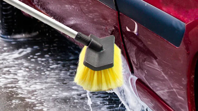 Car cleaning brush with segmented aluminum tube and text highlighting features, used on a car's side panel.