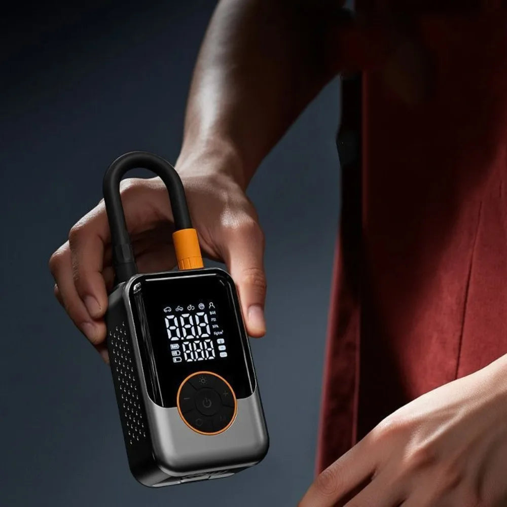 Hand holding the Compact Cordless Tyre Inflator by its hose, showing the digital pressure display and control dial