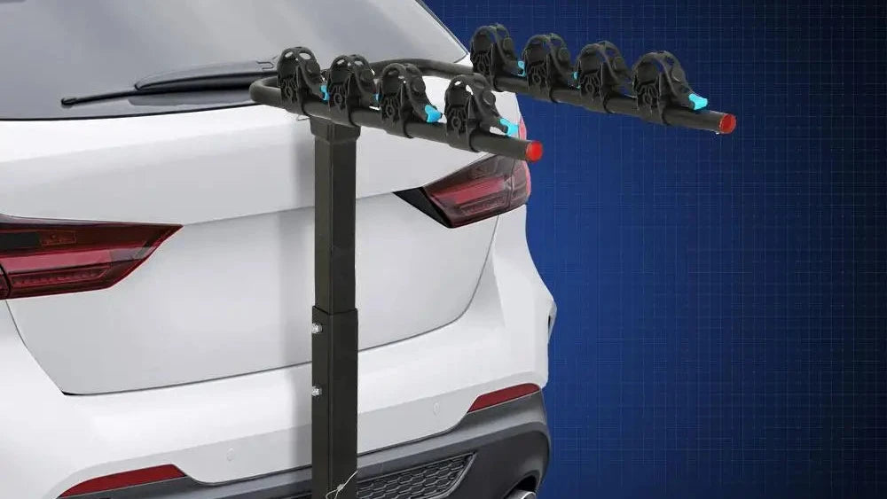 A black 4-bike hitch-mounted car carrier mounted on the rear of a white SUV, shown against a dark blue grid background.