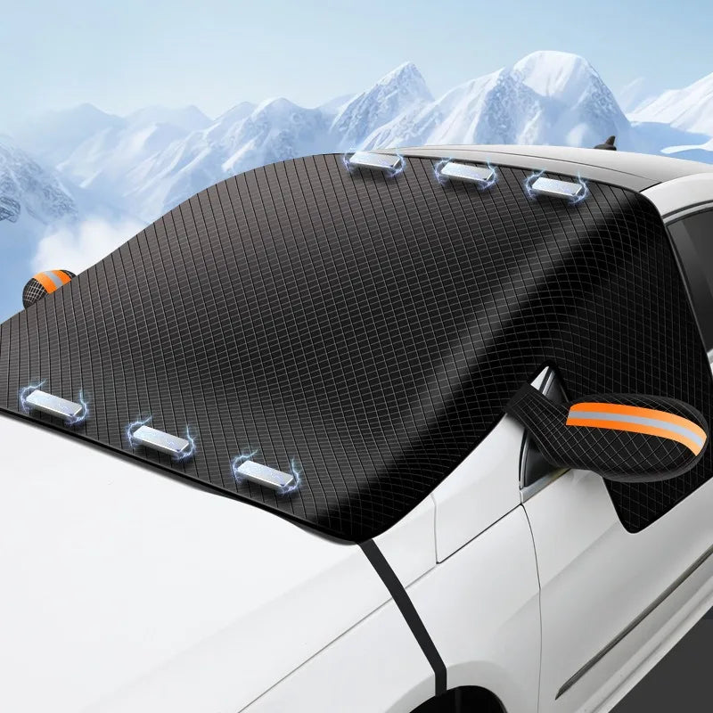 Magnetic Windscreen Frost Cover shielding a car's windscreen and mirrors on a snow-covered mountain road