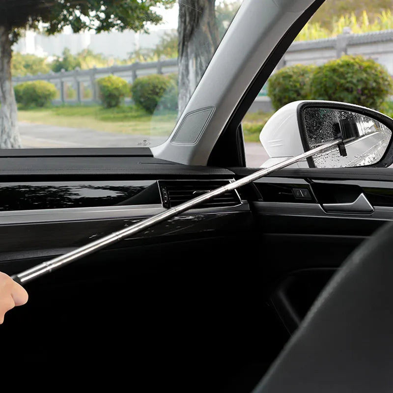 Telescopic Car Rearview Mirror Wiper extended through a car window cleaning the side mirror on a sunny day