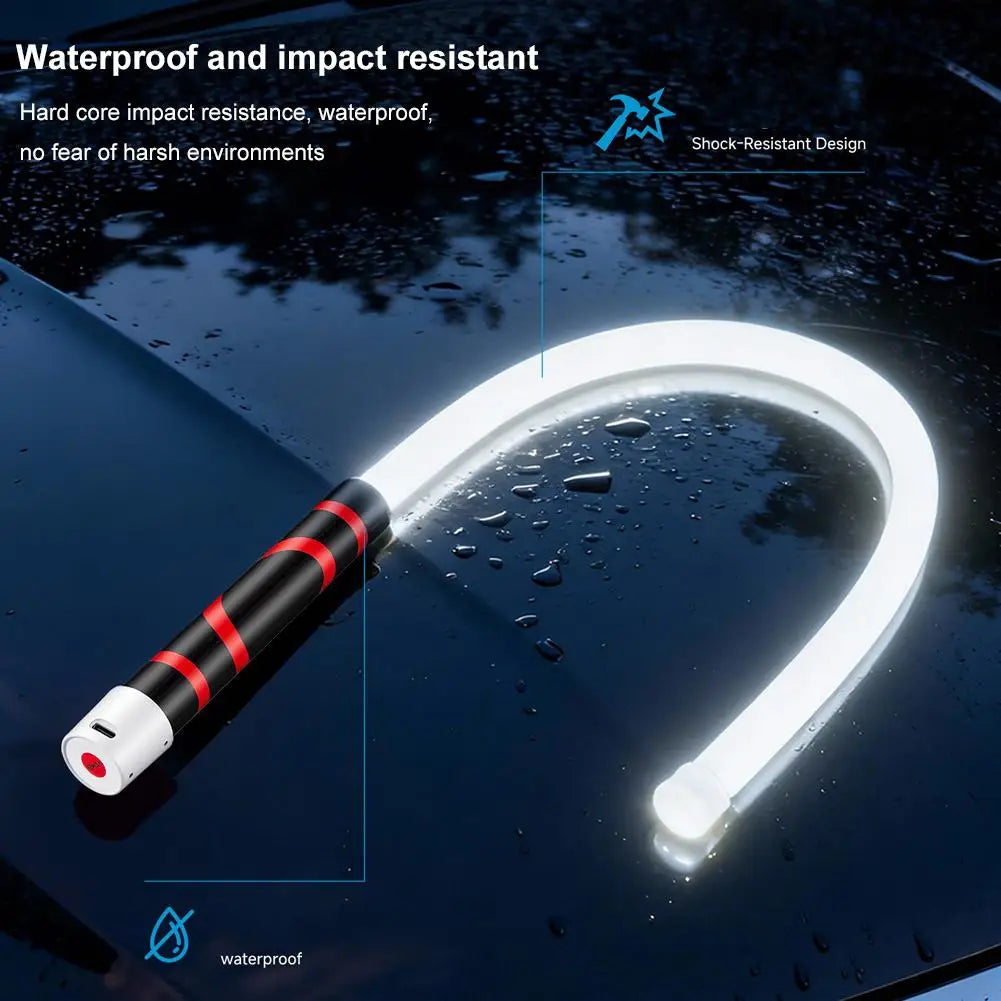 Mechanic in workshop garage holding illuminated Flexible LED Work Light beside car
