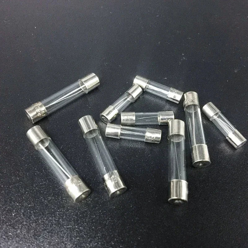 Ten assorted glass fuses from the Auto Glass Fuse Kit scattered on a dark background