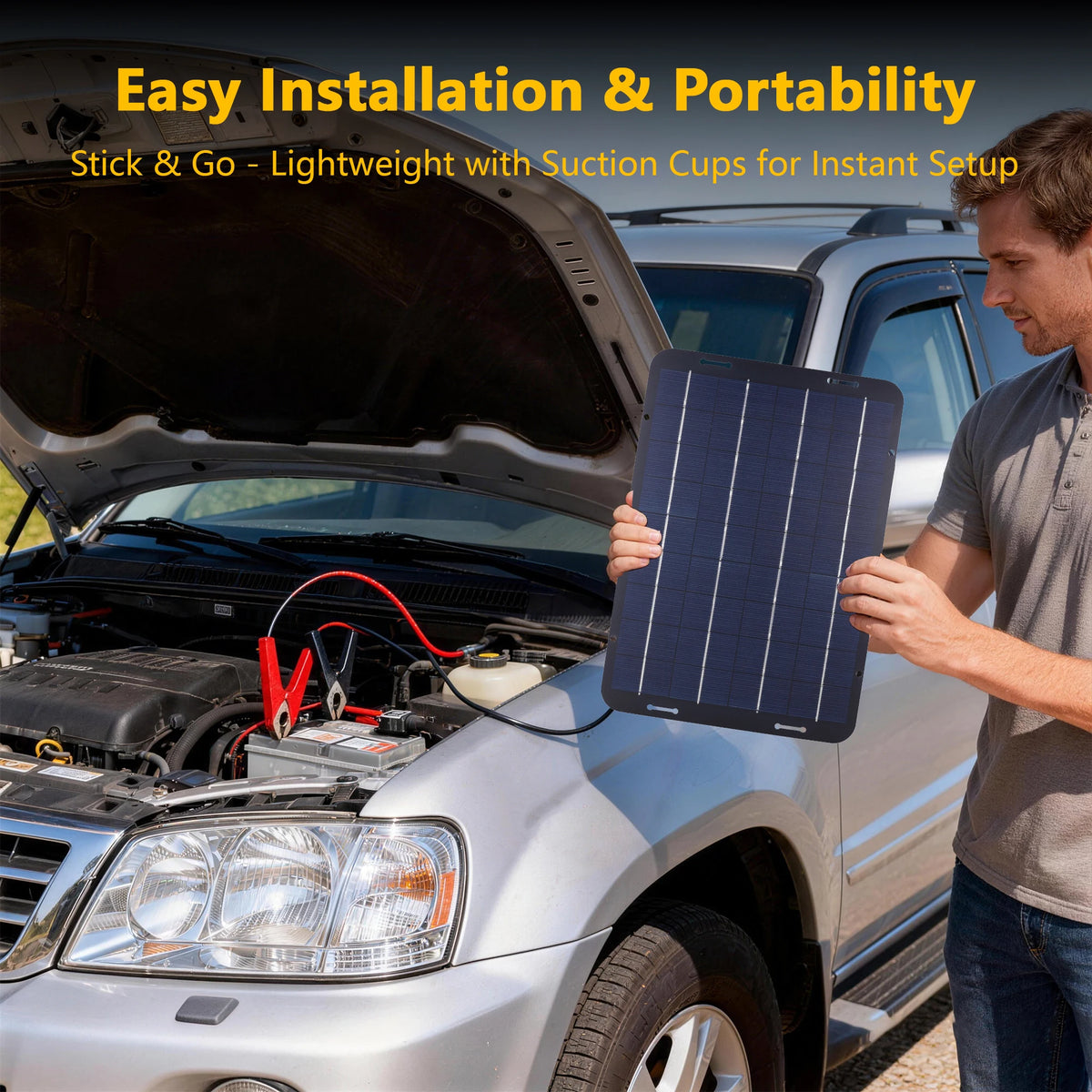 Man holding a solar battery maintainer panel beside an SUV's open bonnet with clips connected to the car battery