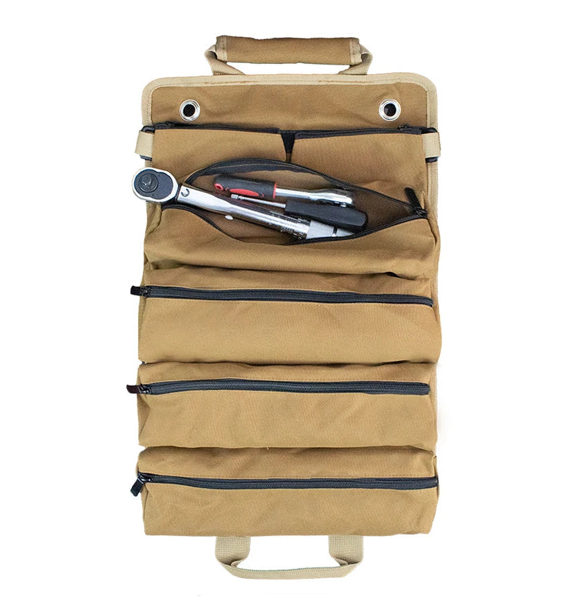 Overhead flat-lay of the Canvas Tool Roll Organiser in Field Khaki fully unrolled on a white background, with one zip pocket open revealing a ratchet and pliers.