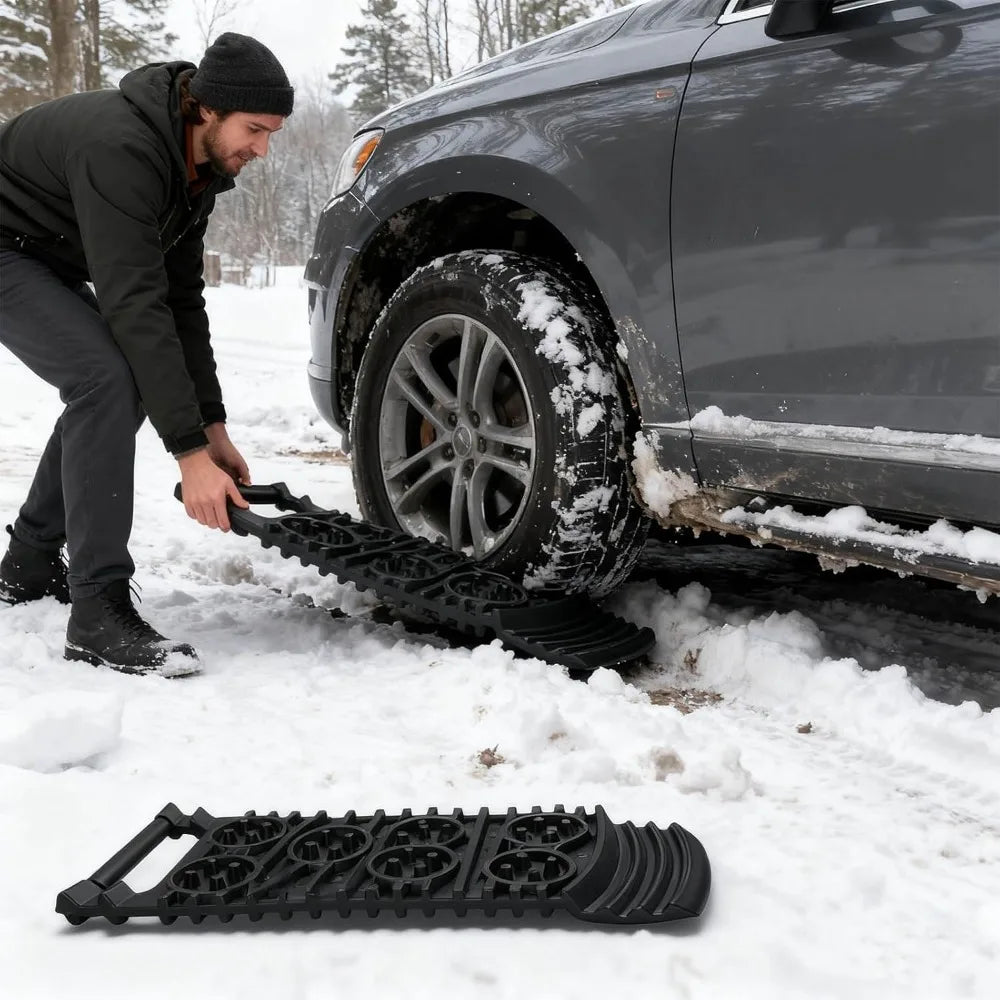 Man placing a Compact Tyre Traction Mat in front of an SUV tyre stuck in snow