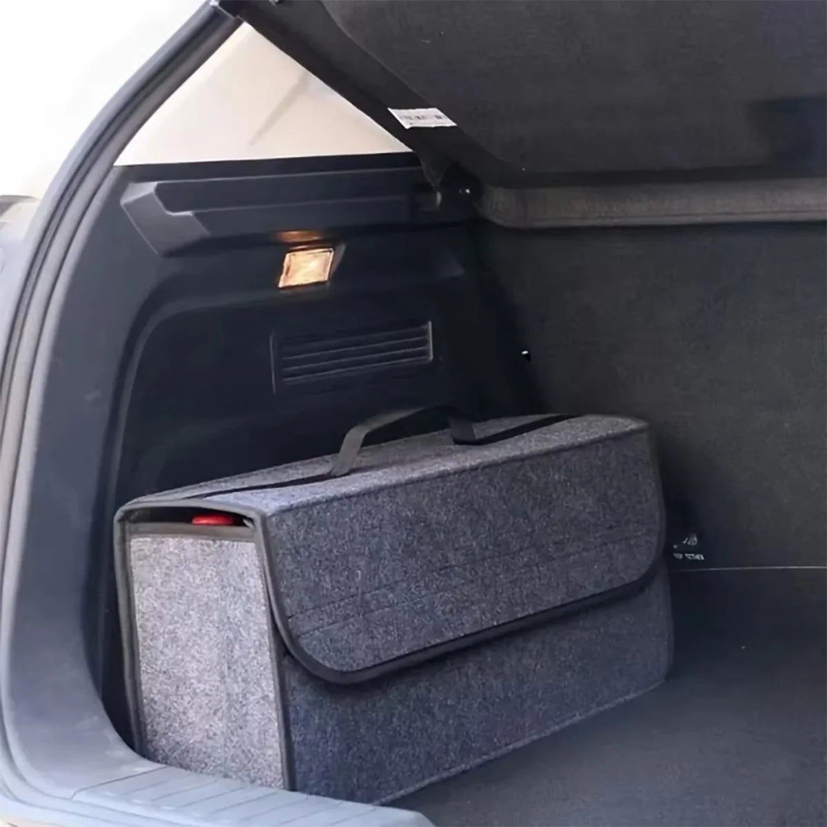 Dark grey felt storage box fitted neatly into the boot of a car, secured against the rear seat backs to organise cargo space.